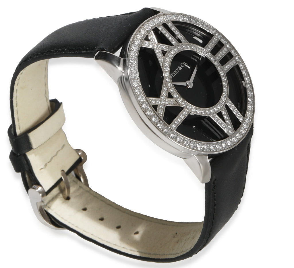 Three-quarter view of Tiffany & Co. Atlas 18kt white gold unisex watch showcasing diamond-set openwork Roman numeral bezel and black leather strap