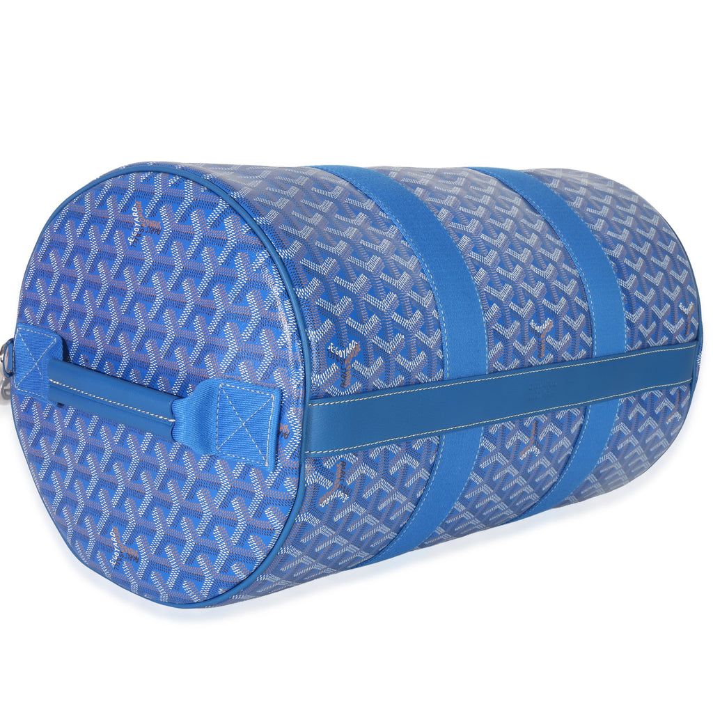 Angled side view of Goyardine Barrel 40 sports bag in sky blue showing signature chevron canvas and dual blue straps