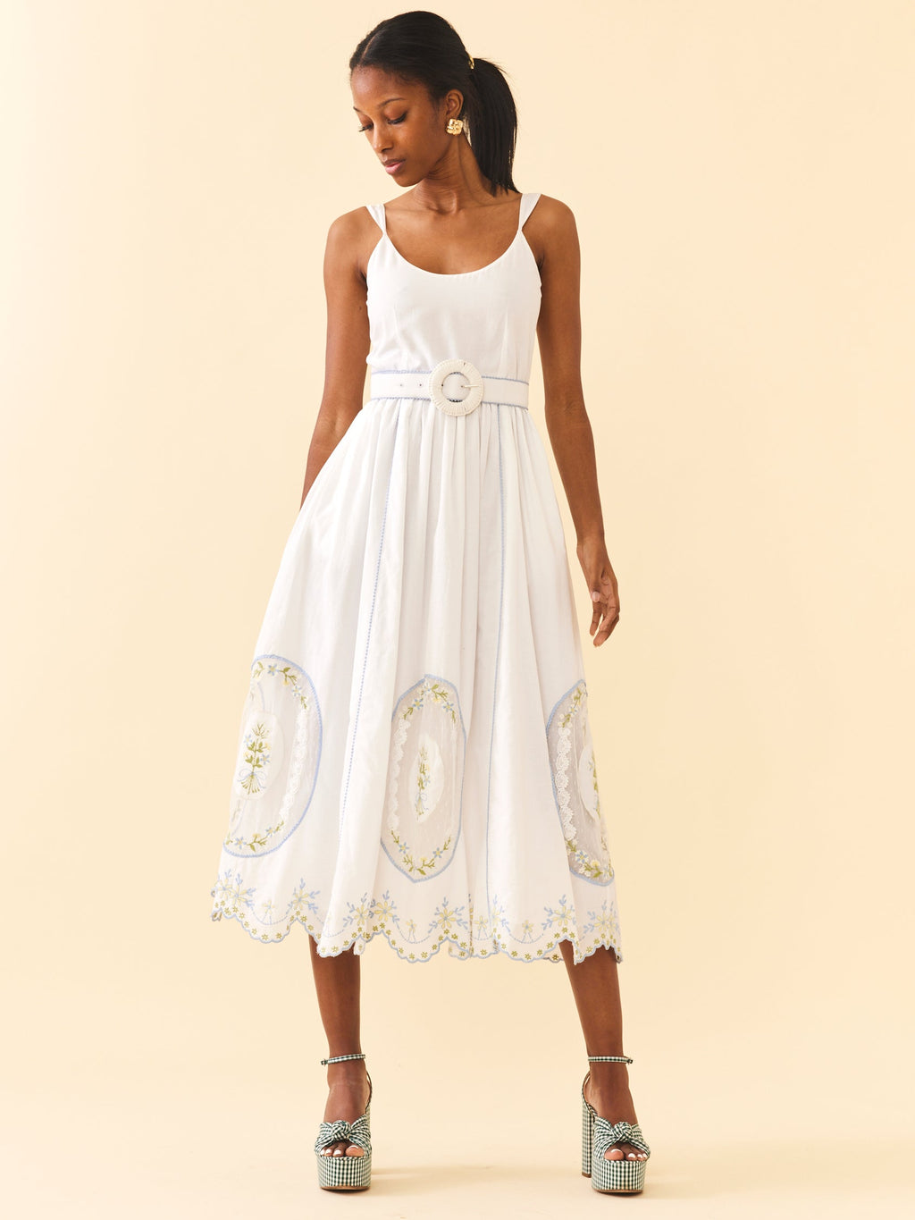 Front view of Katherine Dress in White Whimsy with adjustable straps, belted waist, and embroidered scalloped midi skirt