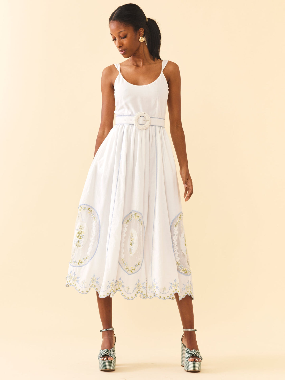 Front view of Katherine Dress in White Whimsy with adjustable straps, belted waist, and embroidered scalloped midi skirt