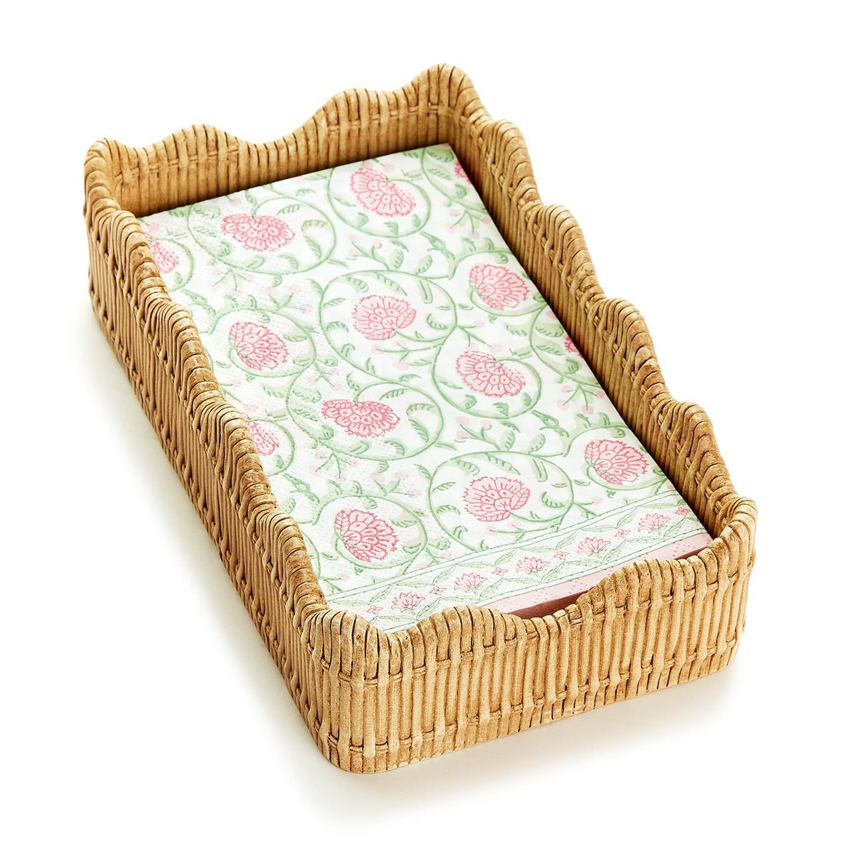 Angled view of scalloped-edge woven napkin holder holding pink floral guest napkins on white background