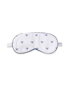 The Adults Twill Sleep Mask in Buzzing Bees by Petite Plume showcases a charming blue bee print with a blue trim, adjustable white strap, and side tag.