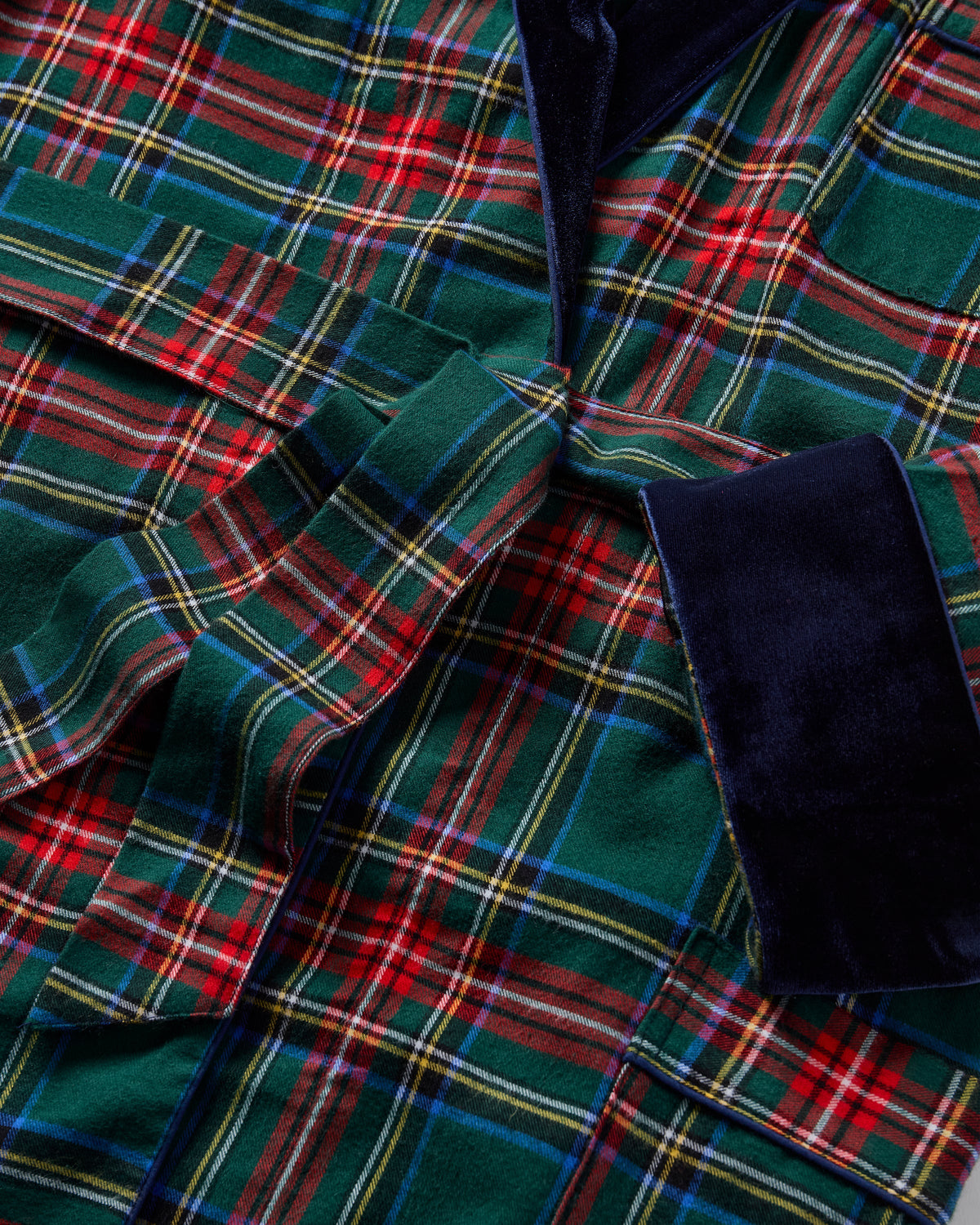 Close-up of men’s Kensington Tartan robe showcasing green and red plaid fabric with navy velvet collar and cuff