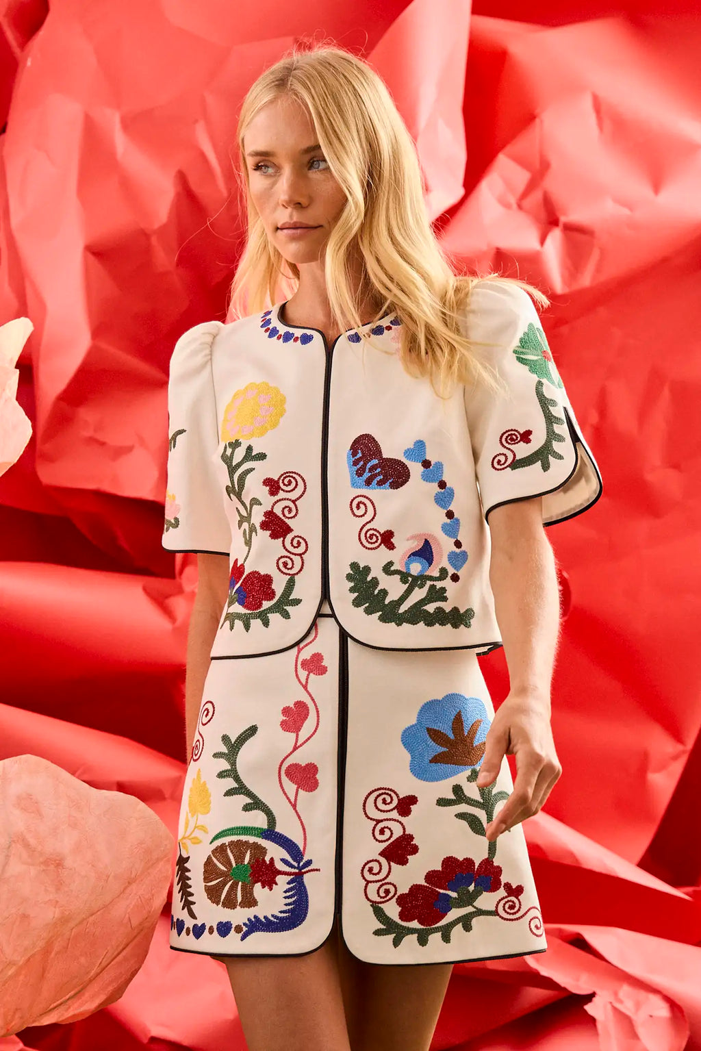 The Dottie Mini Skirt is a white A-line skirt with fitted waist and colorful hem throughout.