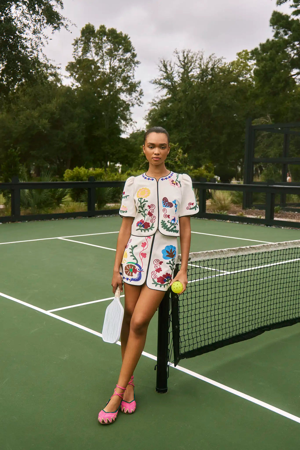 The Dottie Mini Skirt is a white A-line skirt with fitted waist and colorful hem throughout.