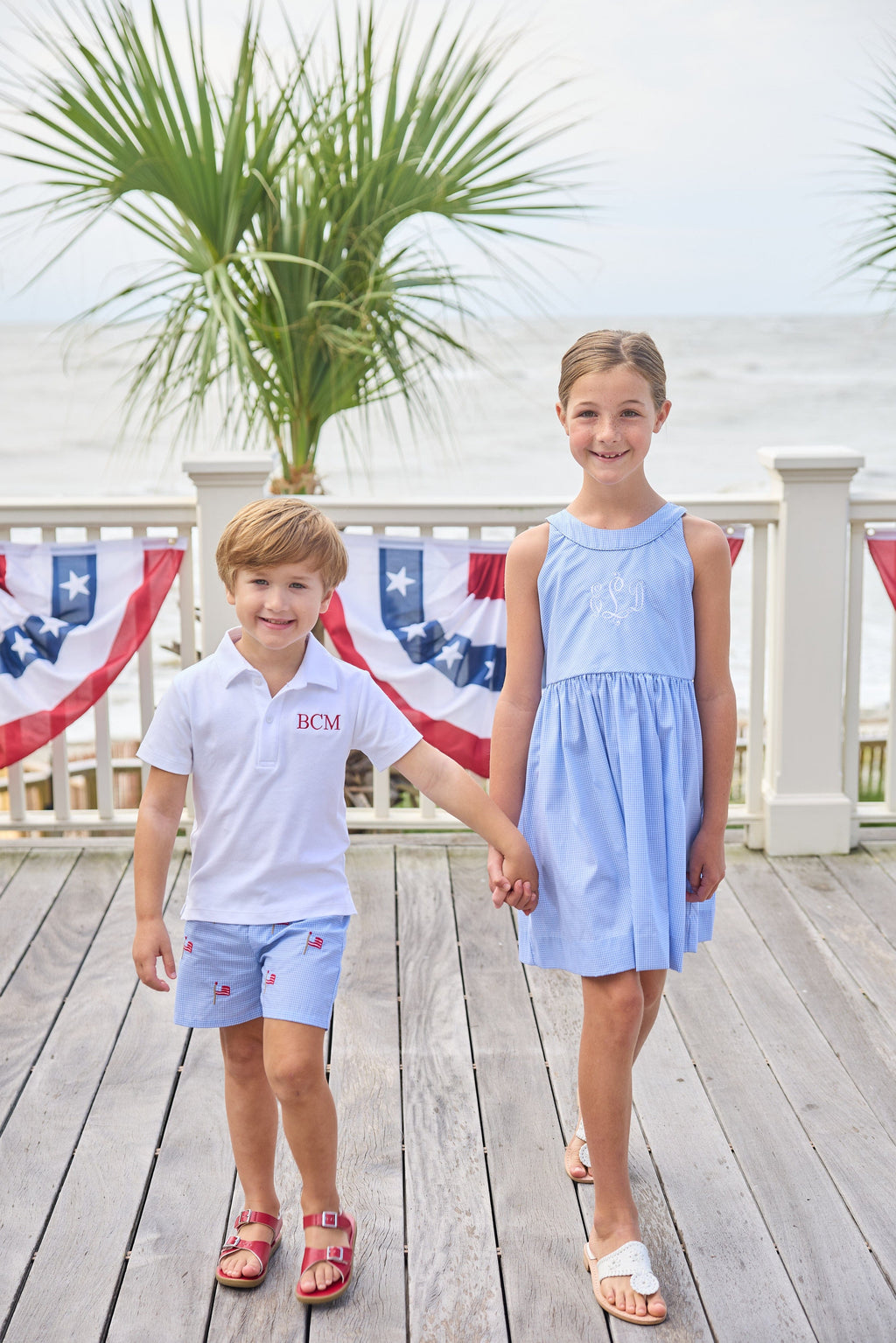 Little English traditional children's clothing.  Royal blue mini gingham sleeveless dress with white ricrac trim and bow tie in back for little girls