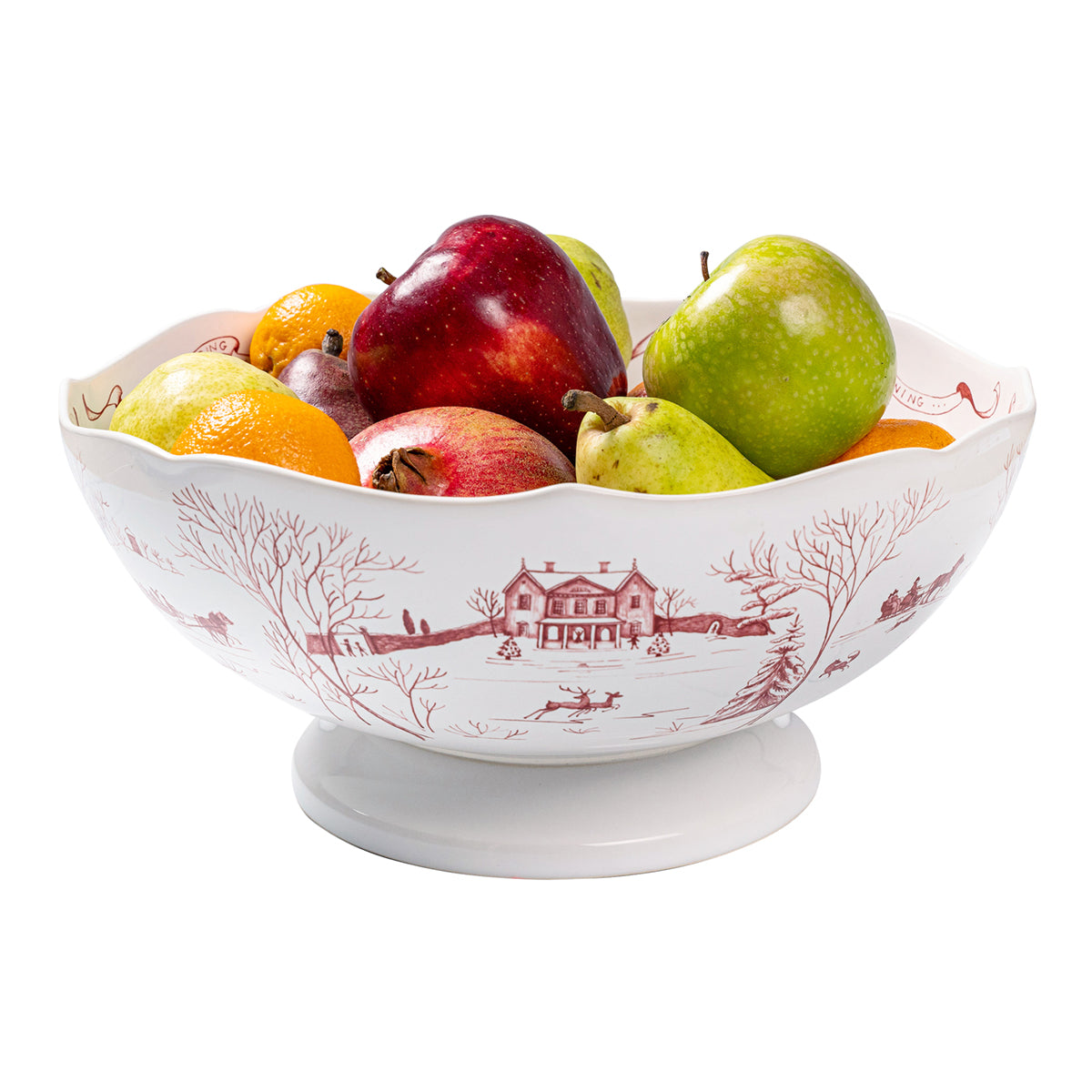 Front view of 13-inch Country Estate Winter Frolic bowl, footed ceramic with red scenic pattern, filled with fruit on white