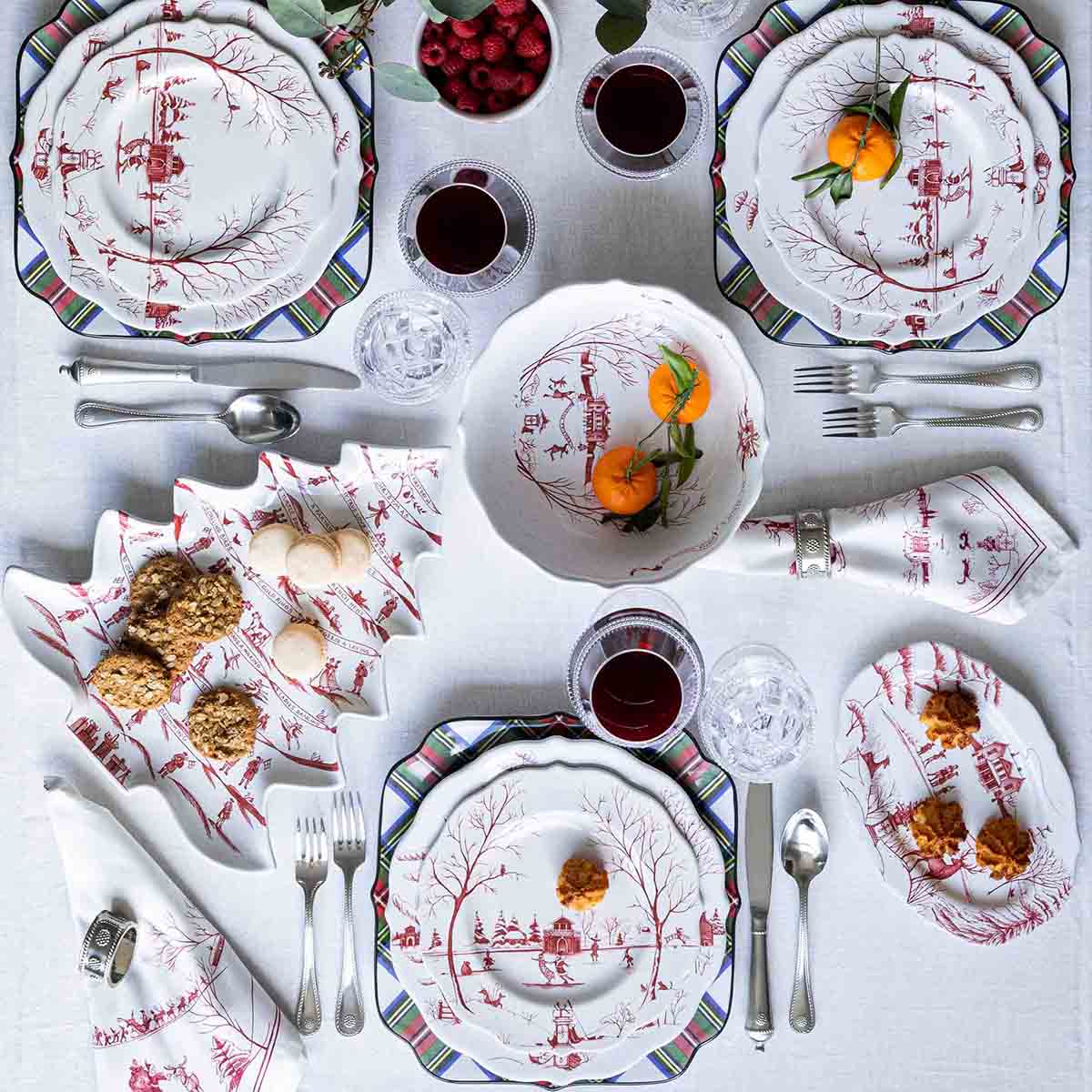 Overhead of 13-inch Country Estate Winter Frolic bowl with red winter village pattern and two clementines