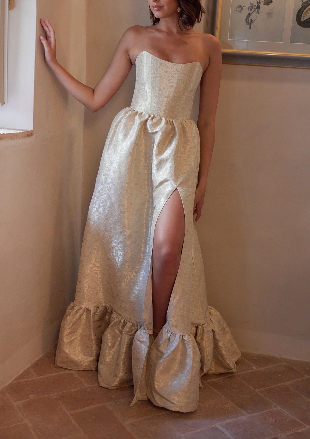 Front view of The Charlotte Dress in Taupe Duchess with strapless corset bodice, high side slit, and gathered ruffle hem