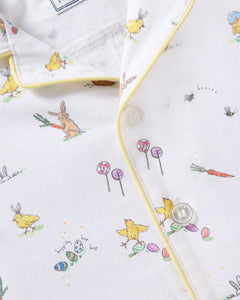 The Babys Twill Romper in Easter Frolic by Petite Plume features a whimsical design of rabbits, chicks, lollipops, and Easter eggs on brushed twill fabric. It includes yellow piping, two white buttons, and is perfect for the season.
