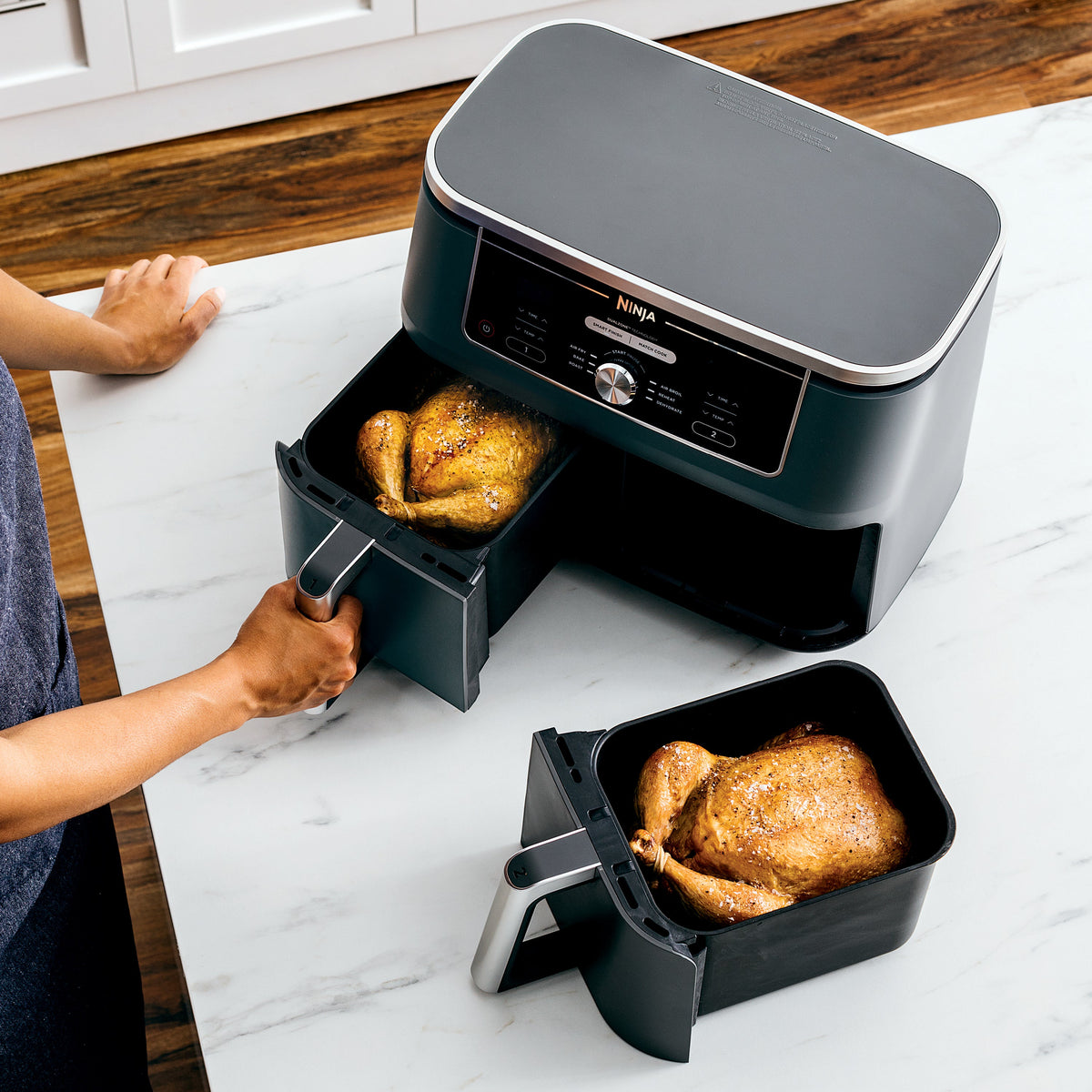 Front view of Foodi 6-in-1 10 qt XL dual-basket air fryer showing two baskets with roasted chickens on a countertop