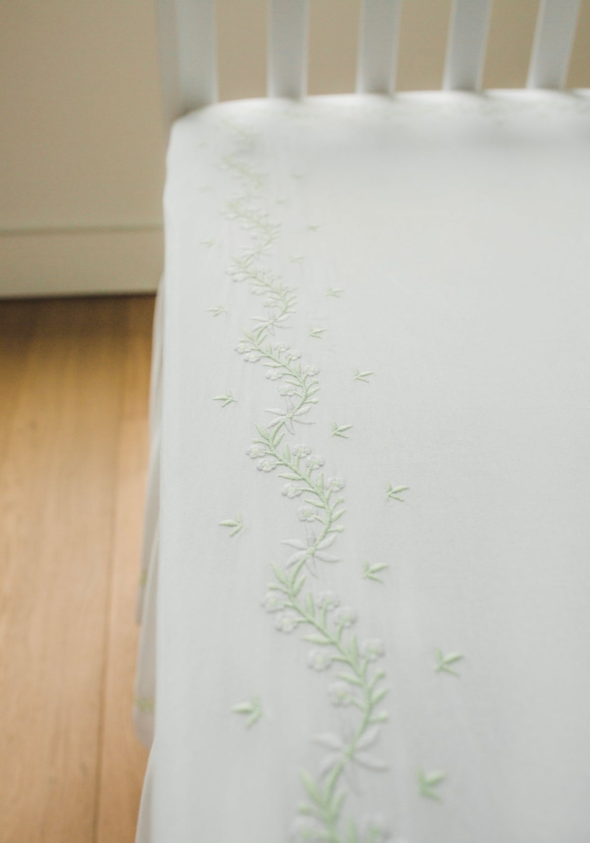 Little English classic nursery goods for baby, white crib sheet with simple light green embroidery along the edges for baby