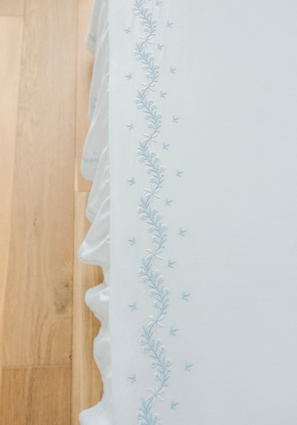 Little English classic nursery goods for baby, white crib sheet with simple light blue embroidery along the edges for baby