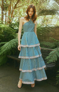 Front view of Emma Dress in navy stripe showcasing halter neckline, tiered maxi skirt with embroidered trim in garden setting