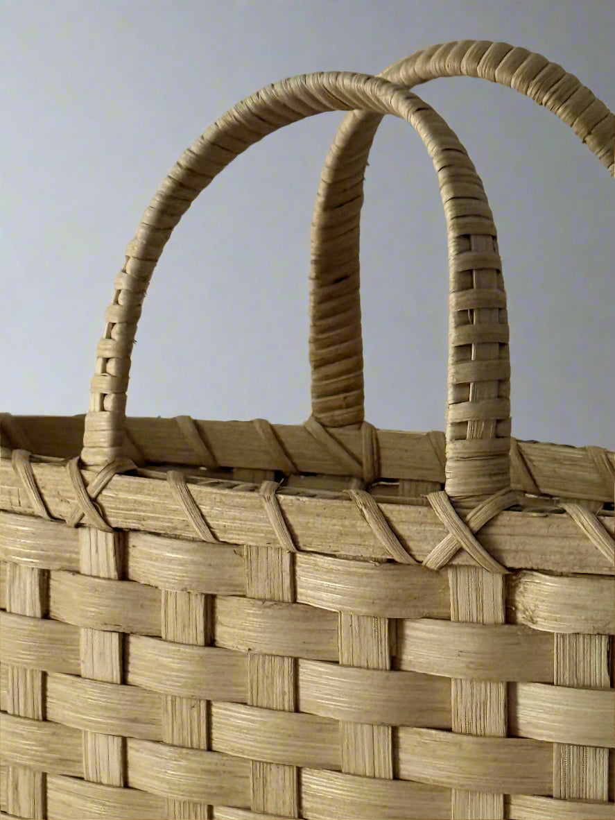 Close-up of a woven basket with a handle on a gray background