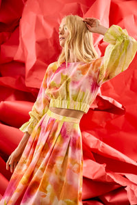 A pleated full skirt in a colorful print with a matching long sleeve top