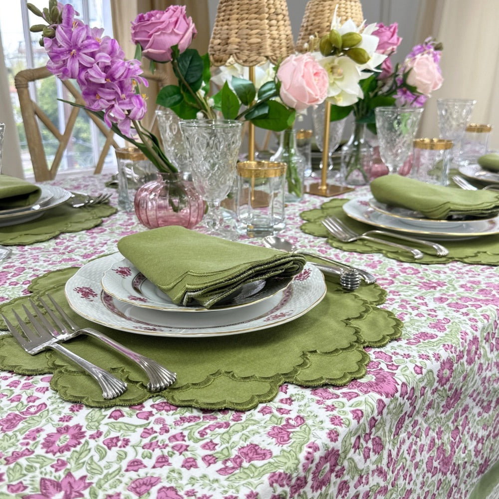 Elegant table setting with floral hand block printed plum and Sage tablecloth, Sage green luxury embroidered placemats and napkins, and pink flowers.