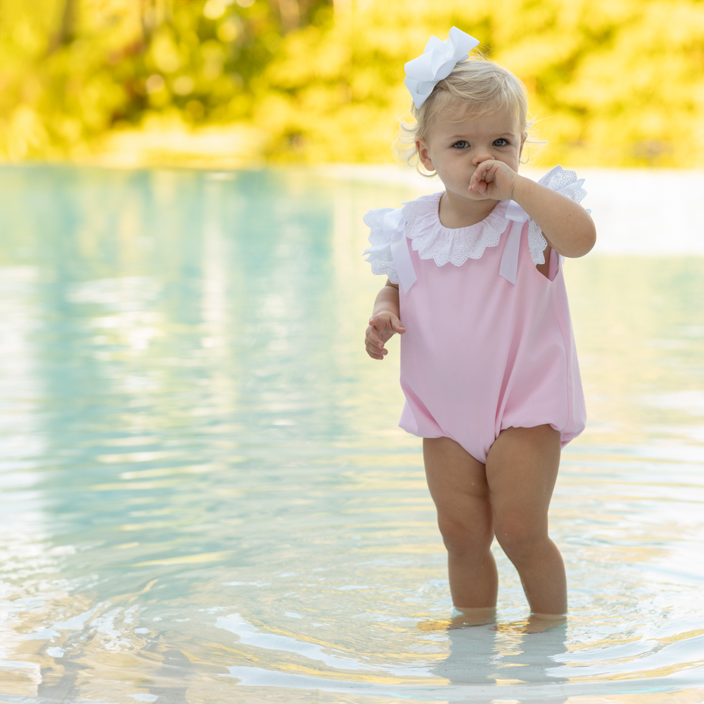 Toddler girl wearing the Henry Duvall Rosie Bubble, a classic pink bubble designed for spring days and special moments.