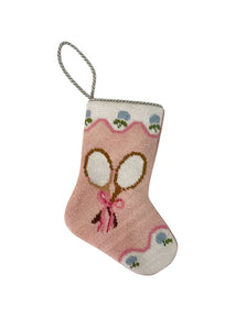 Front view of pink needlepoint stocking with crossed tennis rackets, scalloped white trim and silver loop on white background
