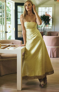 Three quarter view of Katherine Dress in lemon yellow showing strapless sculpted bodice and A line silk skirt with fringe hem