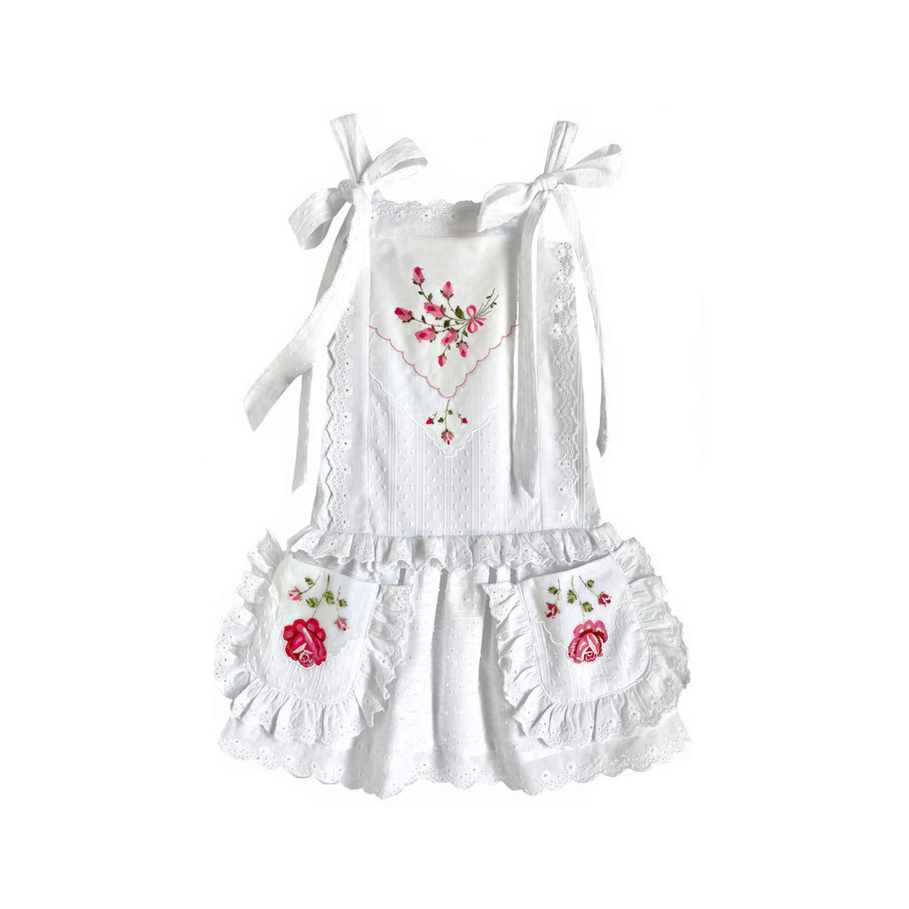 Front view of Heirloom Handkerchief Drop-Waist Dress with pink and red rose appliqués, ruffled pockets and tie shoulder straps