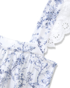 The Womens Pima Clara Short Set in Timeless Toile by Petite Plume showcases a blue floral pattern on white fabric. The strap, detailed with eyelet lace, adds botanical elegance and a delicate touch to the design.