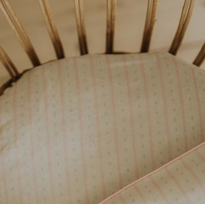 Petal Scallops Crib Sheet in Pink displayed in crib