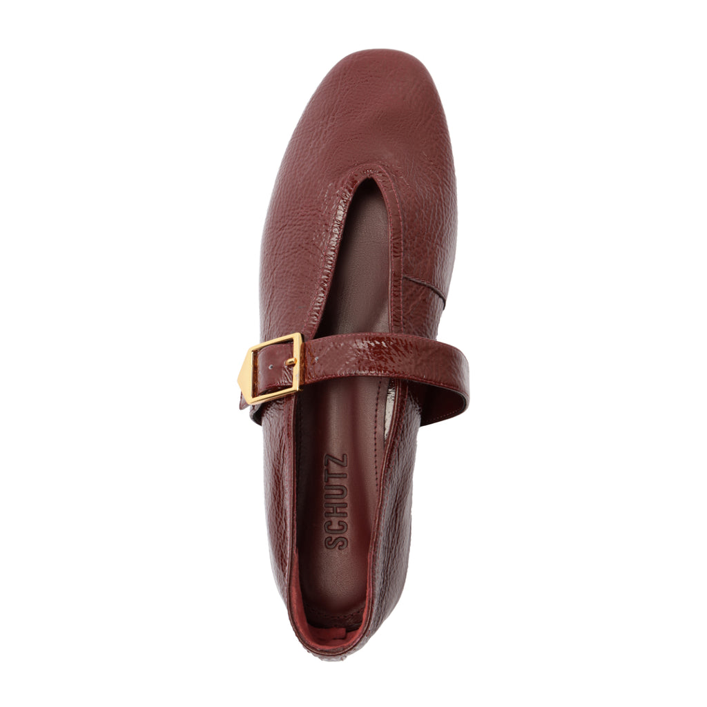 Top view of Schutz Courtney Buckle patent flat in vino showing buckled strap, square toe, glossy finish on white background