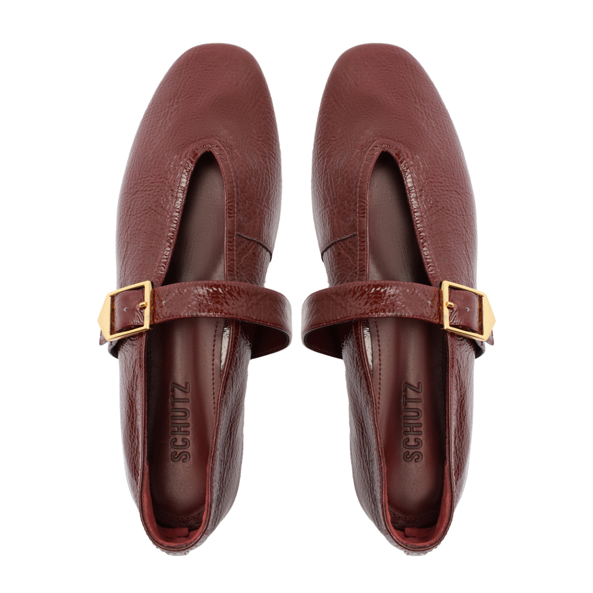 Top view of Courtney Buckle patent flat in vino showcasing square toe, gold buckle strap, and pebbled patent leather on white background