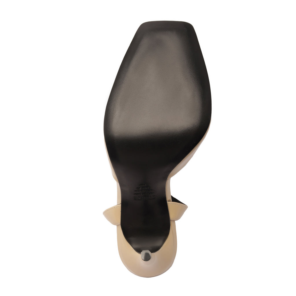 Bottom view of Estella Patent Pump in Natural Nibs showcasing black leather sole and heel tip on white background