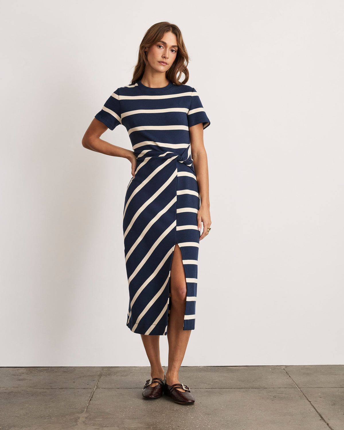 Front view of Short Sleeve Striped Cody Dress in maritime blue and cream showcasing twist-knot waist and side slit, fitted midi on model