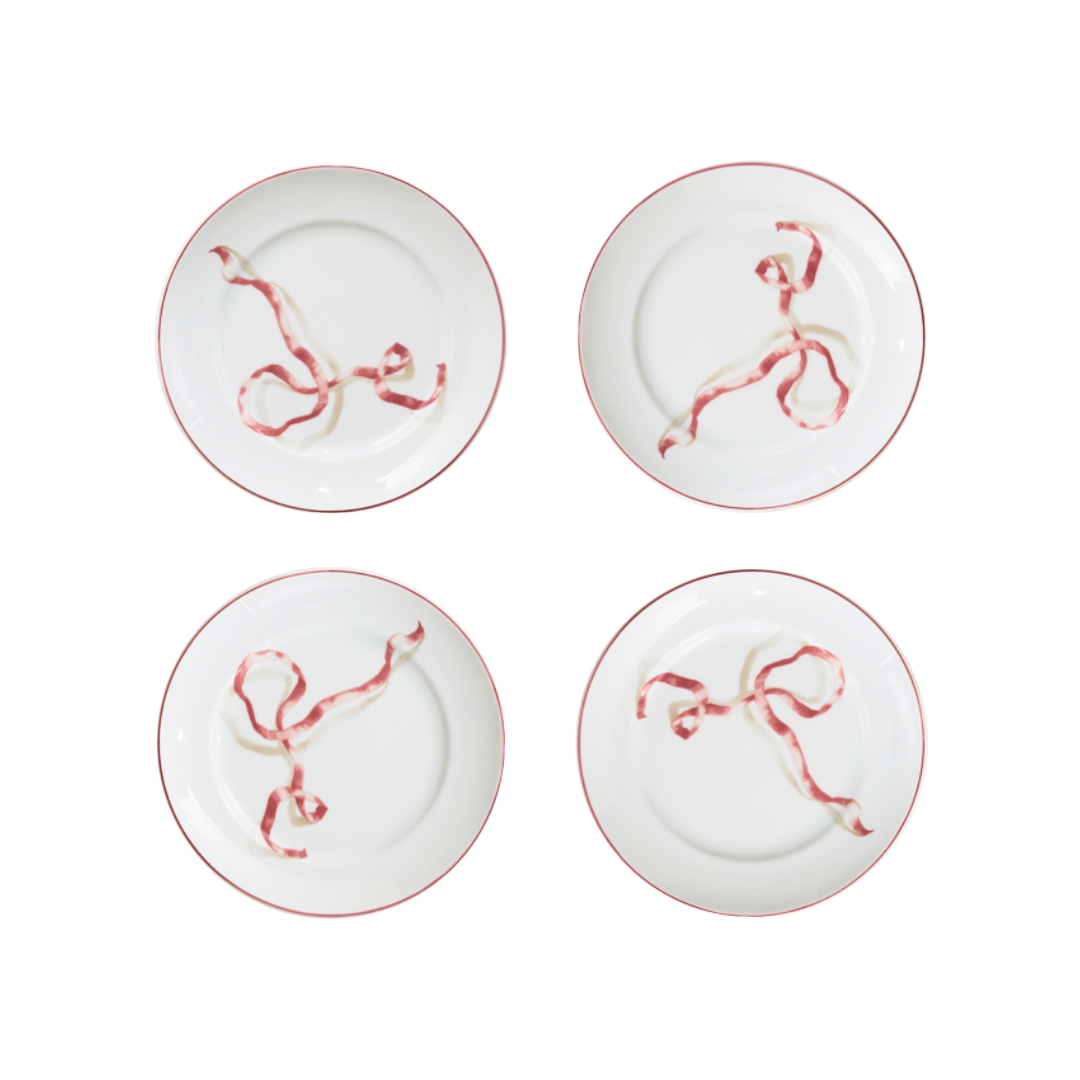 A set of four ribbon dessert plates in pink. HarperÕs Bazaar Best Hostess Gifts for Dinner Parties, Movie Nights, and More. These ribbon-adorned dinner plates can transform even an easy meal into something fit for a downtown It-girl. With three different colors to choose from, you can find the perfect option for home design lovers.