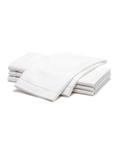 Stacked view of four folded white twill napkins showing hemstitch edge on white background