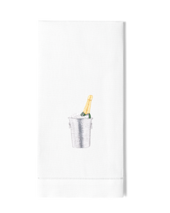 A white hand towel with a hemstitch. A champagne bottle in a silver ice bucket is embroidered in the center.