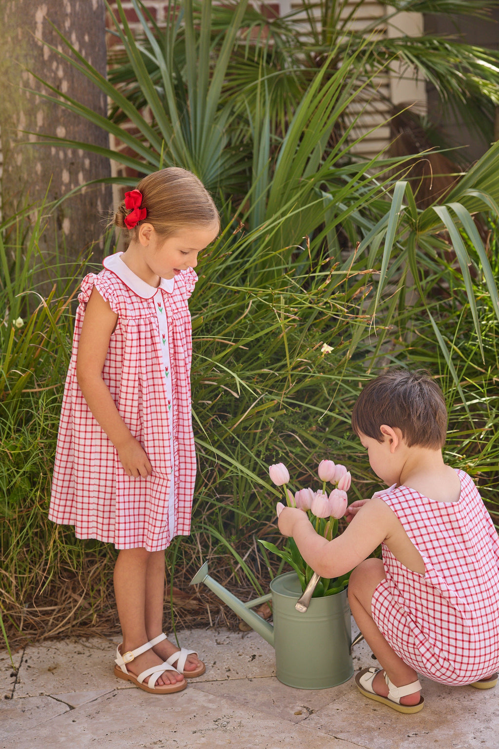 Little English traditional children's clothing. Classic dress for toddler girls in red windowpane with peter pan collar and tulip embroidery