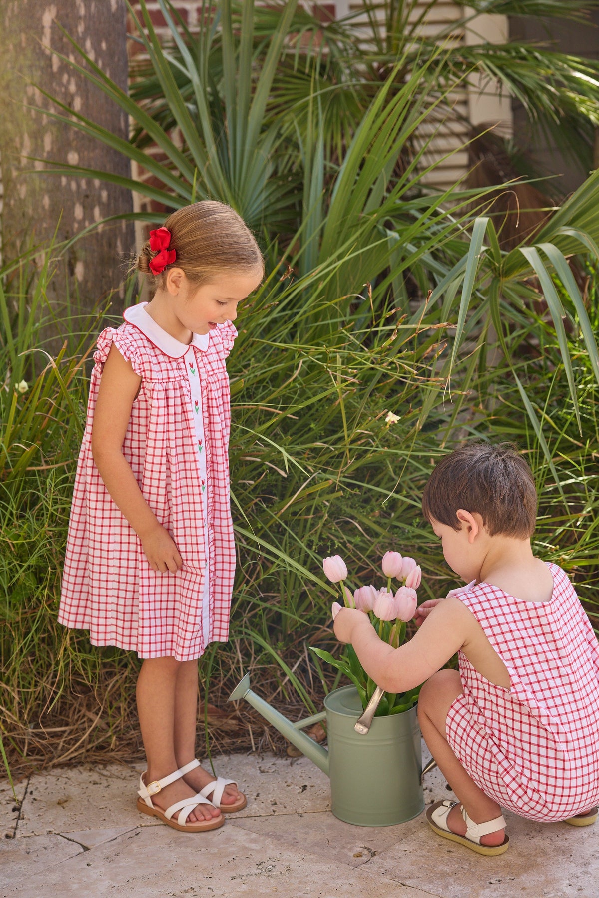 Little English traditional children's clothing. Classic dress for toddler girls in red windowpane with peter pan collar and tulip embroidery