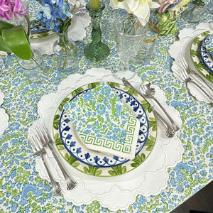 table setting with floral plates, napkins, and silverware on a floral patterned tablecloth with white vegan leather luxury embroidered placemat