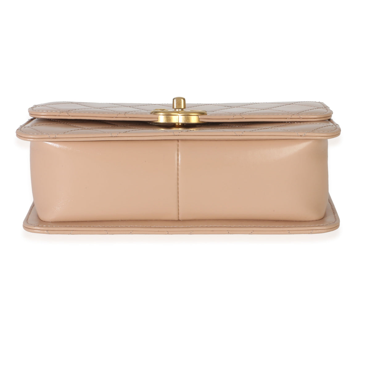 Bottom view of Chanel beige quilted calfskin mini Perfect Fit flap bag showcasing champagne gold turnlock on white background