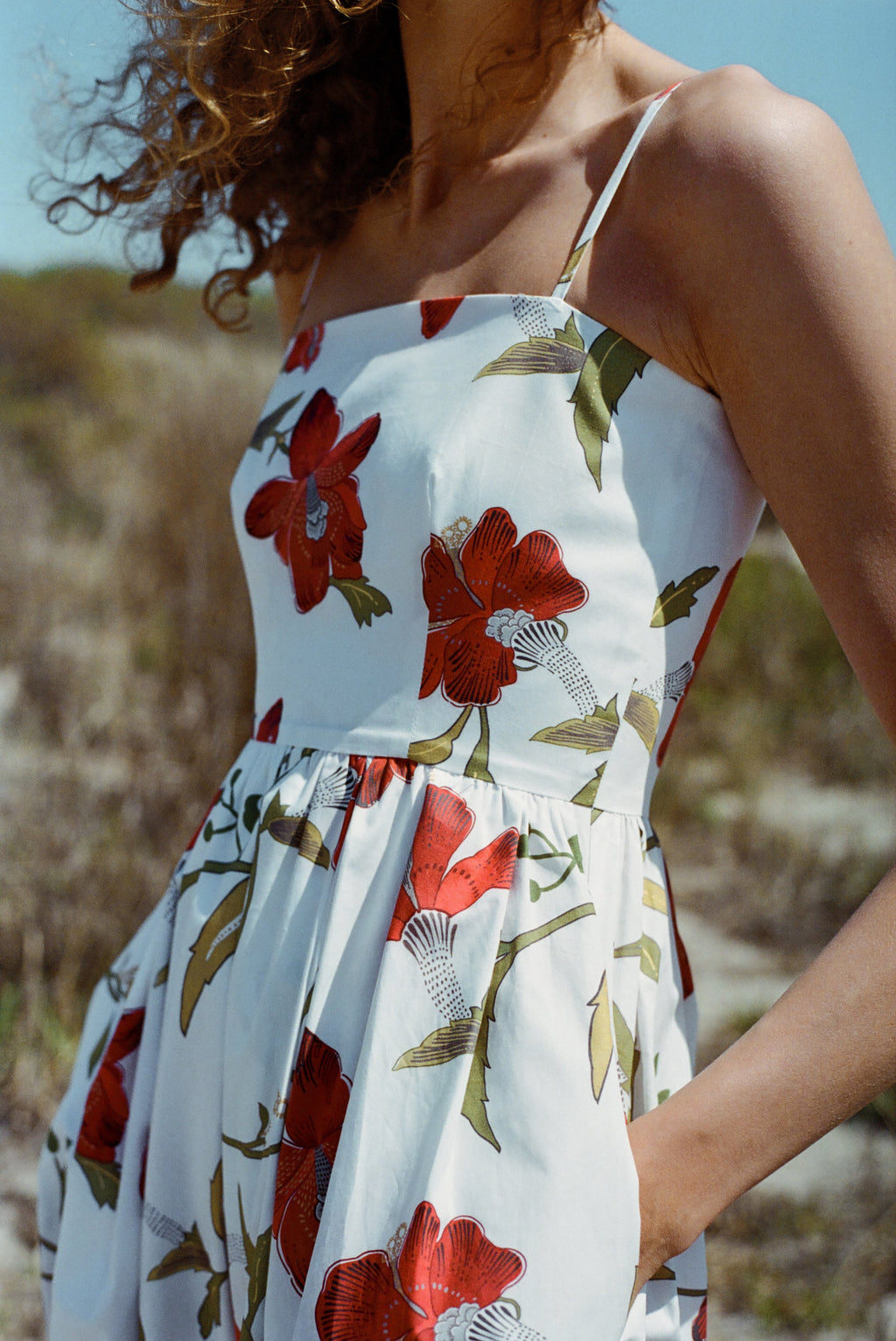 Close-up of Skinny-Strap Poof Dress in Red Hibiscus showing fitted bodice, gathered skirt, skinny straps and side pocket