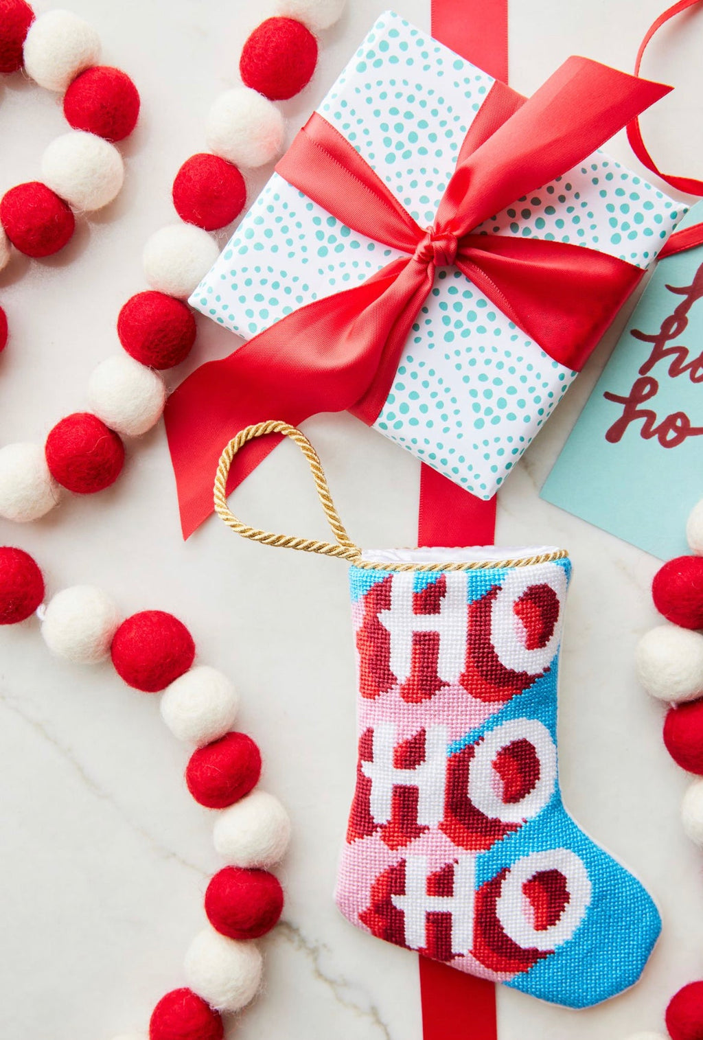 HO HO HO Bauble Stockings styled on vibrant red background with festive holiday accents