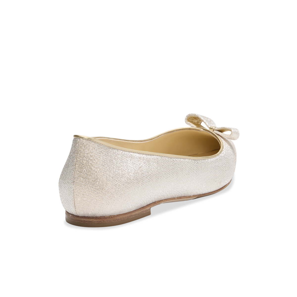 Rear three-quarter view of Natalie flat showcasing champagne lamé textured upper, decorative bow, and low stacked heel on plain background
