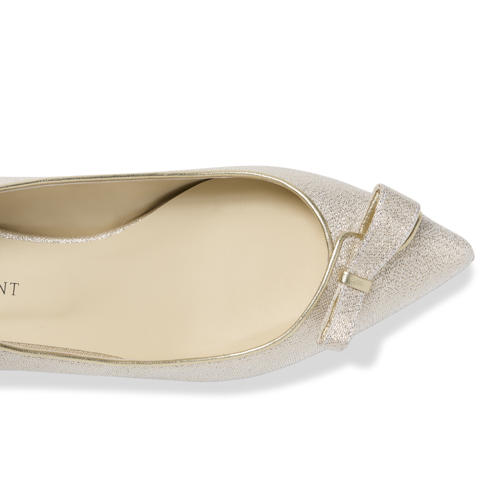 Top view of Natalie pointed-toe flat in champagne lame showing bow detail and metallic shimmer on black background